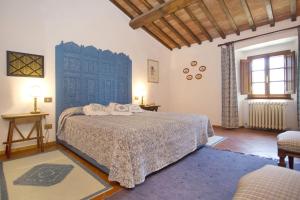 a bedroom with a bed and a blue door at Pozza di Volpaia by Salogi Villas in Radda in Chianti +22 photos