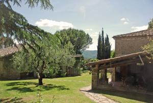 an old stone house with a tree in the yard at Villa Pozza di Volpaia in Radda in Chianti