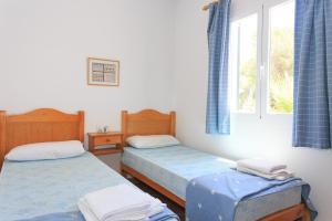 a bedroom with two beds and a window at Villa Toymi in Ciutadella