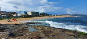 eine Gruppe von Menschen an einem Strand in der Nähe des Ozeans in der Unterkunft apartamento para até 5 pessoas in Vila Velha