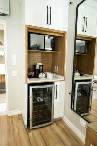 a small kitchen with white cabinets and a mirror at Cape Village Lodge in Durbanville