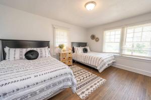 a bedroom with two beds and two windows at Downtown Retreat, Hot Tub, Firepit, Grill in Michigan City