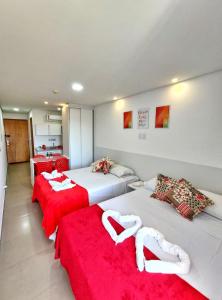 a room with two beds with red sheets at Flat Manawa Beach - Porto de Galinhas in Porto De Galinhas