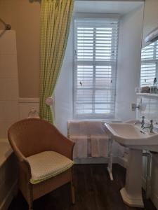 a bathroom with a tub and a sink and a chair at Langass Lodge in Carinish