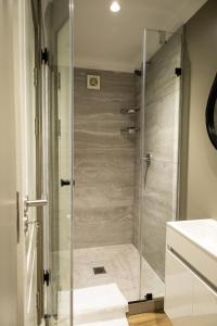 a shower with a glass door in a bathroom at Cape Village Lodge in Durbanville