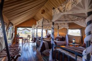 a room with several bunk beds in a tent at Mawe Tented Camp in Serengeti