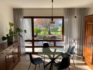 a dining room with a glass table and chairs at Holiday home Punta D'Oro with garden, parking place and lake access at 300 m in Iseo