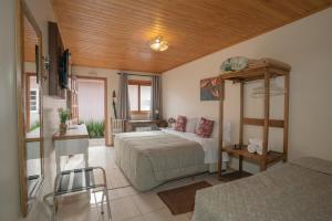 um quarto com uma cama, uma mesa e uma cadeira em Pousada Flor de Tuna em Urubici