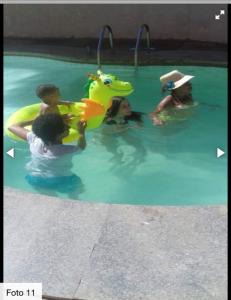 a group of people playing in a swimming pool at Quarto para temporada na praia do corsário in Salvador