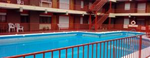 una piscina en un hotel con barandilla roja en Edificio Los andes - n11 en Villa Carlos Paz