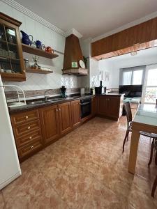 a large kitchen with wooden cabinets and a table at La Oliverica in Caudete