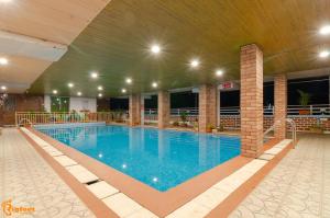 a large swimming pool in a large building at White House Beach Resort, Nagaon in Nagaon