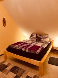 Bett mit Kissen darauf in einem Zimmer in der Unterkunft Ferienwohnung Erika in Waischenfeld