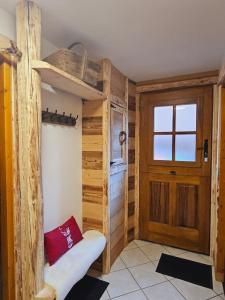 a room with wooden walls and a door and a bench at Le Banc Des Seilles in Bonvillard