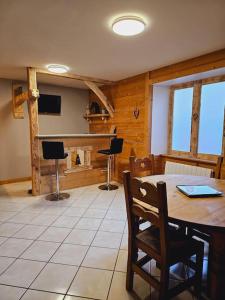a dining room with a table and chairs and a fireplace at Le Banc Des Seilles in Bonvillard