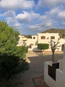 eine Gruppe weißer Gebäude in einem Hof mit Bäumen in der Unterkunft Casa Buganvilla con piscina en San José Sotillo in San José