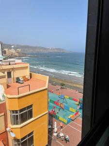 Blick auf einen Strand mit Spielplatz und das Meer in der Unterkunft Gloriamar Las Canteras in Las Palmas de Gran Canaria