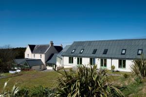 grupa białych domów z czarnymi dachami w obiekcie Langass Lodge w mieście Carinish