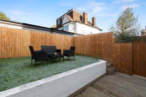 a backyard with a fence and a table and chairs at Star London Vivian Avenue 3-Bed Oasis with Garden in The Hyde