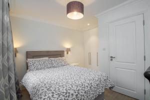 een slaapkamer met een bed met een zwart-wit dekbed bij Marylebone Village Apartments in Londen