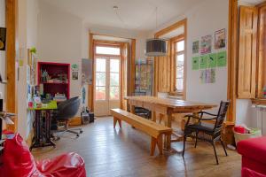 uma sala de estar com uma mesa de madeira e cadeiras em This Is Lisbon Hostel em Lisboa