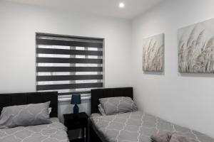 a bedroom with two beds and a window at Star London Vivian Avenue 3-Bed Oasis with Garden in The Hyde