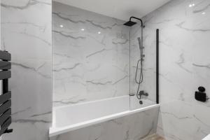 a bathroom with a shower with white marble walls at Star London Vivian Avenue 2-Bed Haven in The Hyde