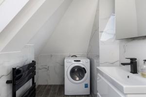 een witte wasruimte met een wasmachine bij Flat 5 - Star London Vivian Lane 2-Bed Residence in The Hyde