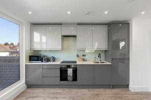 a kitchen with white cabinets and a stove at Flat 5 - Star London Vivian Lane 2-Bed Residence in The Hyde