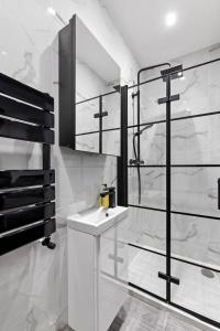 a white bathroom with a sink and a mirror at Star London Vivian Avenue 2-Bed Retreat with Garden in The Hyde