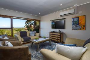 a living room with a couch and a tv at San Lameer Villa 14101 - 3 Bedroom Classic 6 pax - San Lameer Rental Agency in Southbroom