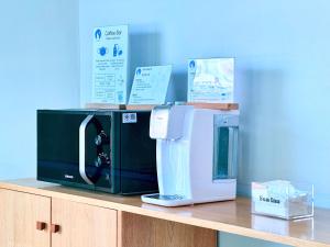 a microwave and a coffee maker sitting on a counter at Sun Inn in Songkhla