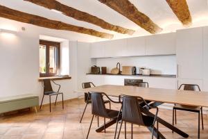 cocina y comedor con mesa de madera y sillas en Vicolo 10, en Asti
