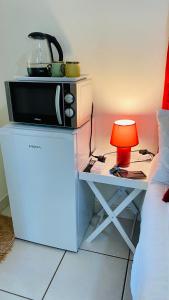 einen Tisch mit einer Mikrowelle und einer Lampe neben einem Bett in der Unterkunft Dundee Bun Private Room in Dundee