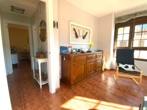 ein Wohnzimmer mit einem Holzschrank und einem Stuhl in der Unterkunft LA TUDANCA DE CASASOLA Sin sorpresas, oficial, Comillas 5 min in Ruiloba