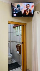 ein Bad mit WC und ein TV an der Wand in der Unterkunft Dundee Bun Private Room in Dundee