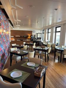 une salle à manger avec des tables et des chaises dans un restaurant dans l'établissement City Hotel Tilburg, à Tilbourg