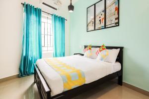 1 dormitorio con 1 cama grande y cortinas azules en OYO Home KC Arcade en Kochi