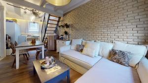sala de estar con sofá blanco y pared de ladrillo en LE NID DE L'ILL, Magnifique Duplex Cosy Petite France en Estrasburgo