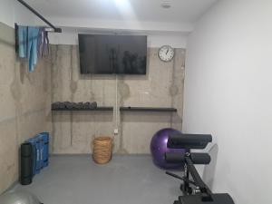 Zimmer mit einem lila Stuhl und einer Uhr an der Wand in der Unterkunft Calma Suites Tejeda in Tejeda