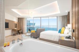 Panorama Nha Trang Inn في نها ترانغ: غرفة في الفندق مع سرير وحوض استحمام
