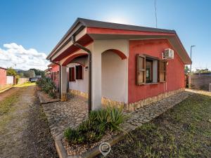 una pequeña casa roja y blanca en una calle en House Charlotte, en Solinas