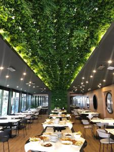 un restaurante con mesas y sillas y techo verde en JR Hotels Bologna Amadeus, en Bolonia