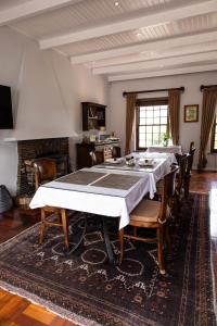 Cape Village Lodge في دوربانفيل: غرفة طعام كبيرة مع طاولة وكراسي