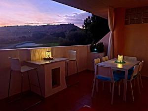 2 Tische und Stühle auf einem Balkon mit Aussicht in der Unterkunft Hacienda Dona JULIA GOLF Estepona in Casares