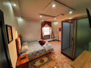 Schlafzimmer mit einem Bett und einer Glasdusche in der Unterkunft DARKOM in Ad-Dakhla