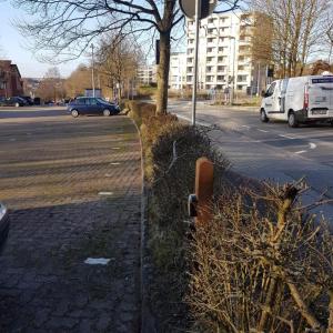 une clôture à côté d'une rue avec des voitures garées dans la rue dans l'établissement Stadtnah an der Förde 104, à Flensbourg