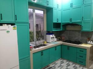 una cucina con armadi blu e lavandino di Homestay Insan a Melur