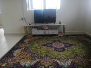 a living room with a television and a rug at Homestay Insan in Melur