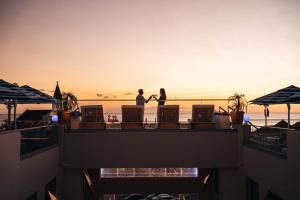 two people standing on a balcony watching the sunset at Elements Hotel & Shops Curaçao in Willemstad